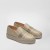 Złote espadryle na wysokiej plecionej platformie, ujęcie z boku. Cholewka z połyskującego materiału zdobiona pasami kryształków oraz haftowanym logo MP. Eleganckie buty typu slip-on na białym tle.
